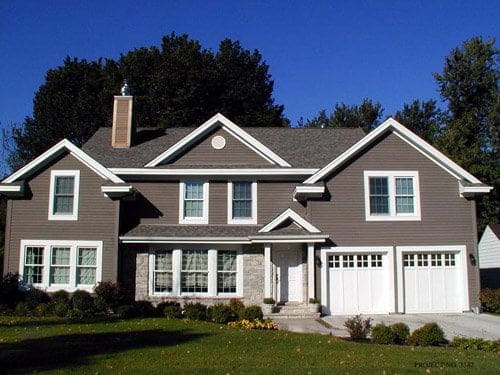 huge house with white garage door and gray sidings